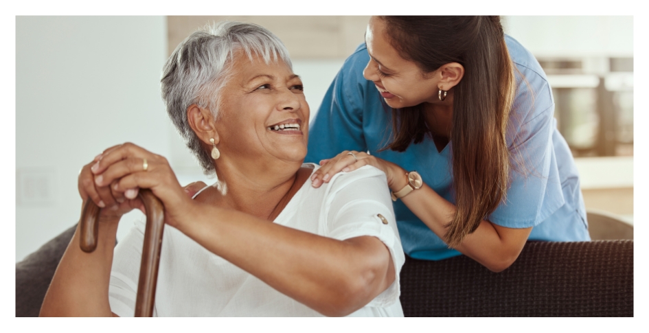 Nurse smiling at senior woman with cane