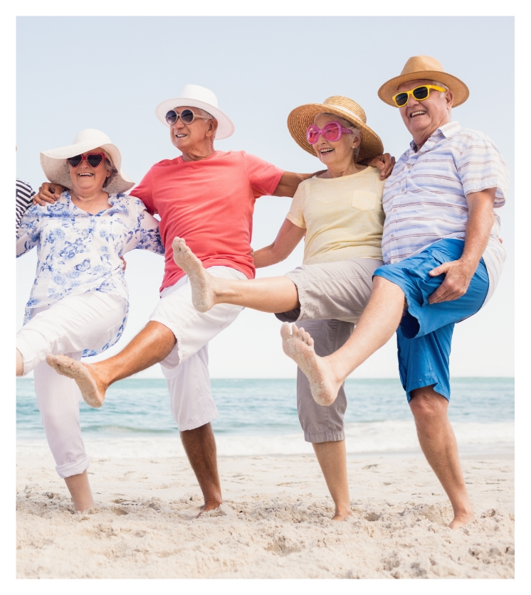 Seniors at the beach in hats and sunglasses doing the cancan